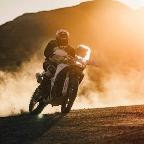 piloto corrinedo por el desierto con su moto